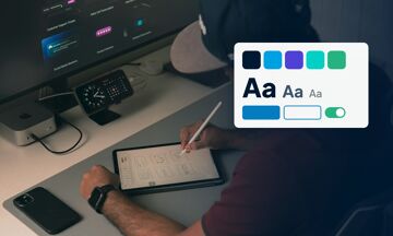 Un designer dessine sur une tablette devant un écran, avec une palette de couleurs, des styles de texte et des boutons du design system